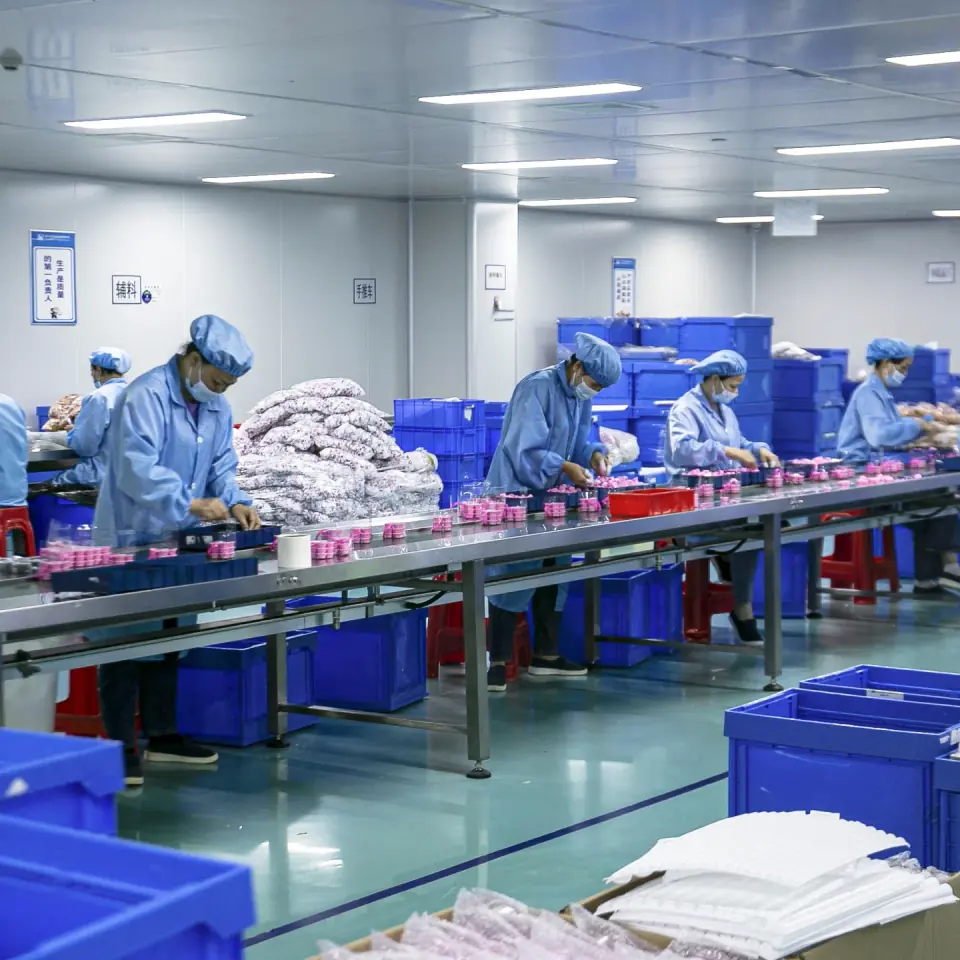 Équipe de production MLM Glitter sur une ligne de conditionnement de cosmétiques OEM à Shenzhen
